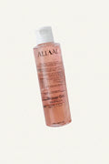 Person holding a bottle of ALLAAL shower gel with a white background